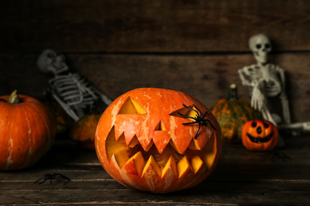 Carved Halloween pumpkin on dark wooden background, closeupの写真素材