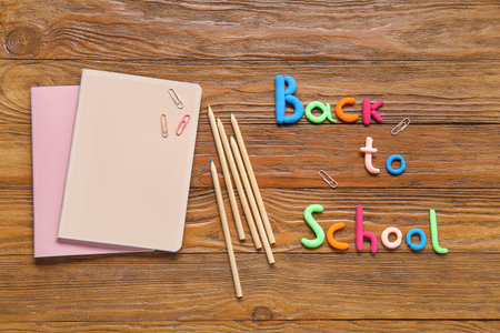 Text BACK TO SCHOOL and stationery on wooden backgroundの写真素材