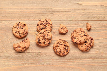 Tasty cookies with chocolate chips on wooden background