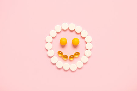 Smile made of different pills on pink backgroundの写真素材