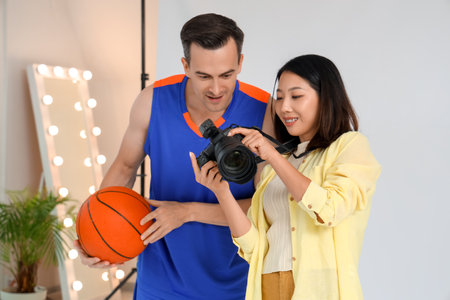 Female photographer working with basketball player in studioの写真素材