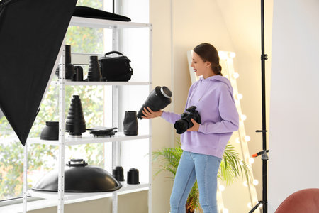 Female photographer with camera working in studioの写真素材