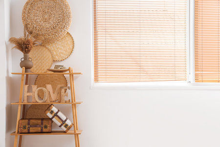 Wooden shelving unit with decor near white wallの写真素材