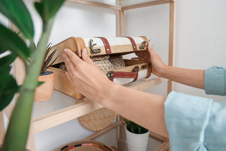 Woman putting suitcase on shelving unit, closeupの写真素材