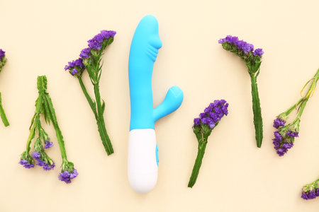 Composition with beautiful lavender flowers and vibrator on beige backgroundの写真素材