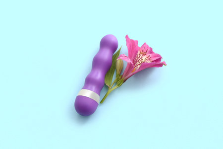 Beautiful alstroemeria flower and vibrator on blue background