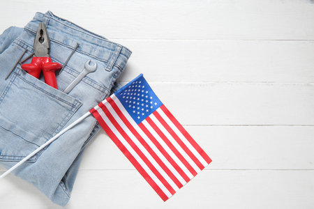 Jeans with tools and USA flag on white wooden background. Labor Day celebrationの写真素材