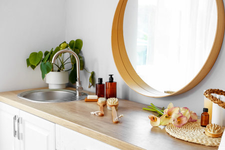 Mirror, bath accessories and sink on wooden countertop in bathroom, closeupの写真素材