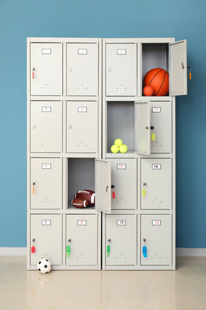Modern locker with sports equipment near blue wallの写真素材