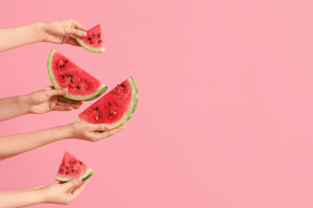 Female hands with slices of ripe watermelon on pink backgroundの写真素材