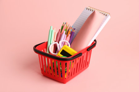 Basket with different stationery on pink backgroundの写真素材