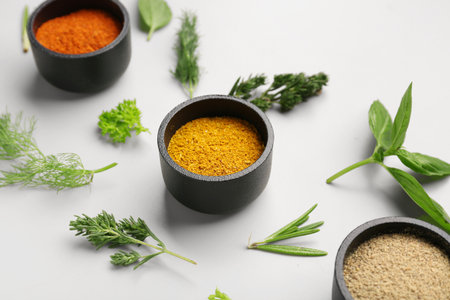 Composition with fresh herbs and different spices on light background, closeupの写真素材