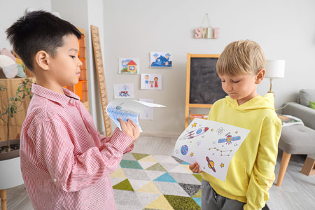 Cute little boys with drawings at home