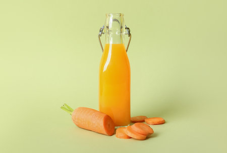 Bottle of fresh carrot juice on green backgroundの写真素材