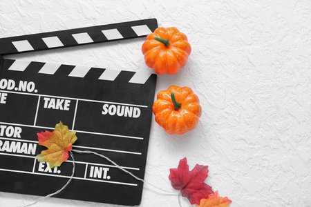 Clapperboard with Halloween decor on textured white backgroundの写真素材