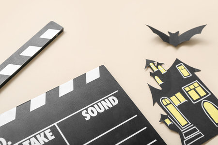 Clapperboard with paper Halloween decor on beige backgroundの写真素材