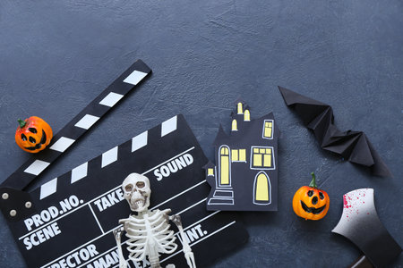 Clapperboard with different Halloween decor on grunge blue backgroundの写真素材