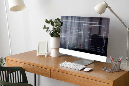 Programmer's workplace with computer and eucalyptus in light officeの写真素材