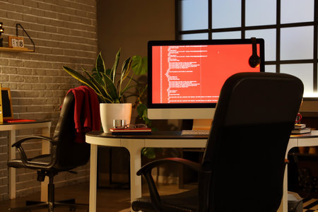 Programmer's workplace with computer in dark officeの写真素材