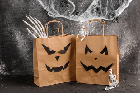 Shopping bags with decorations for Halloween on gray backgroundの写真素材