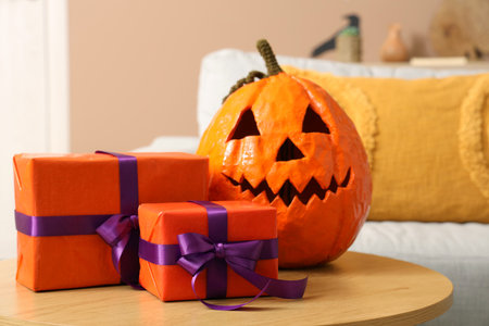 Halloween pumpkin with gifts on table in living room, closeupの写真素材