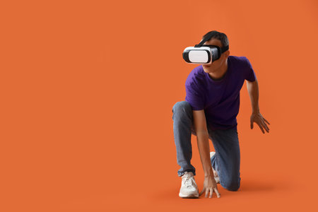 Young man using VR glasses on red backgroundの写真素材