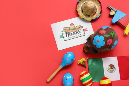Greeting card with text MEXICO INDEPENDENCE DAY, sugar skull, maracas flag of Mexico on red backgroundの写真素材