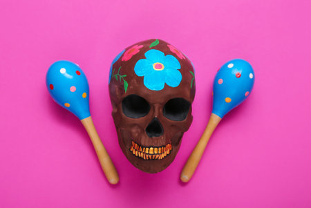 Painted human skull for Mexico's Day of the Dead (El Dia de Muertos) with maracas on pink backgroundの写真素材