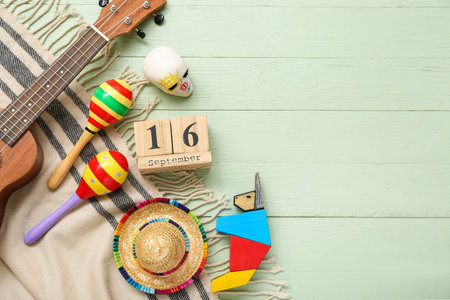 Cube calendar with date SEPTEMBER 16, maracas and Mexican decor on green wooden background. Mexico's Independence Day celebrationの写真素材