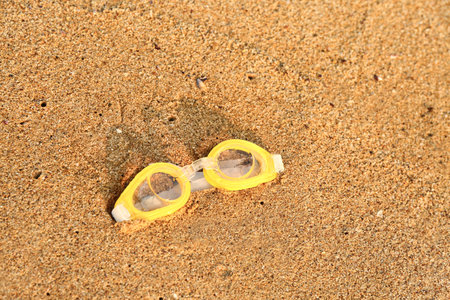 New swimming goggles on sandの写真素材