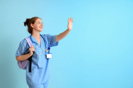 Female medical student with backpack on blue backgroundの写真素材
