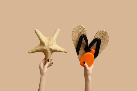 Female hands with summer accessories on beige backgroundの写真素材