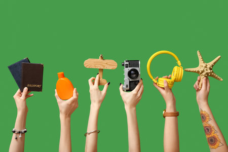 Female hands with summer accessories and passports on green backgroundの写真素材