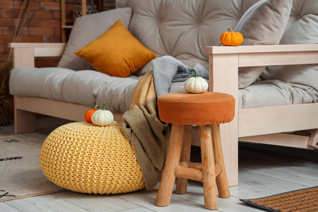 Halloween pumpkins on stool, pouf and couch in living roomの写真素材
