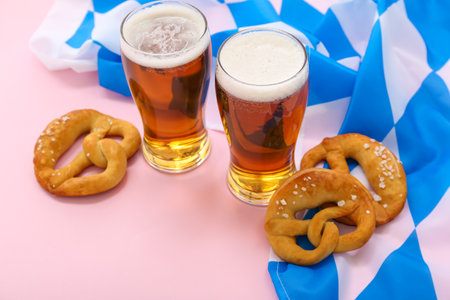 Soft pretzels, glasses with beer and flag of Bavaria on pink backgroundの写真素材