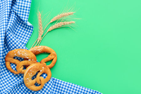 Soft pretzels and wheat spikelets on green backgroundの写真素材