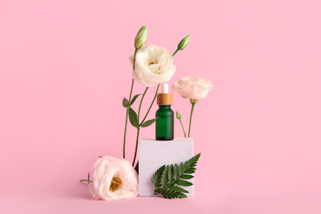 Composition with bottle of essential oil, plaster podium and beautiful eustoma flowers on pink backgroundの写真素材