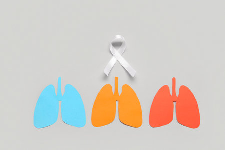 Colorful paper lungs with white ribbon on gray background. Lung cancer conceptの写真素材