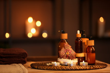 Spa composition with burning candles on table in dark salon, closeupの写真素材