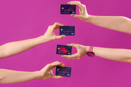 Young women with credit cards on purple background, closeupの写真素材