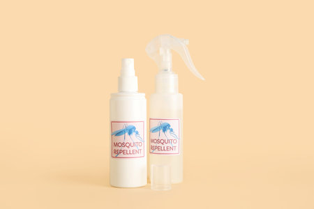 Mosquito repellent sprays on beige background