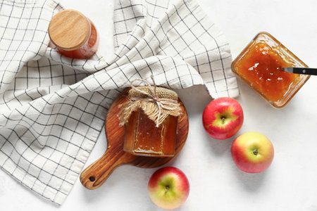 Jars and glass bowl of sweet apple jam on white backgroundの写真素材