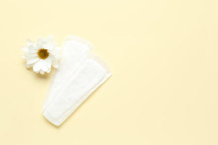 Menstrual pads and chamomile flower on color backgroundの写真素材
