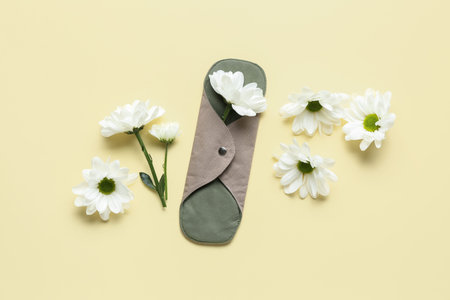 Composition with reusable menstrual pad and chamomile flowers on color backgroundの写真素材