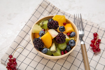 Bowl of fresh fruit salad on light backgroundの写真素材