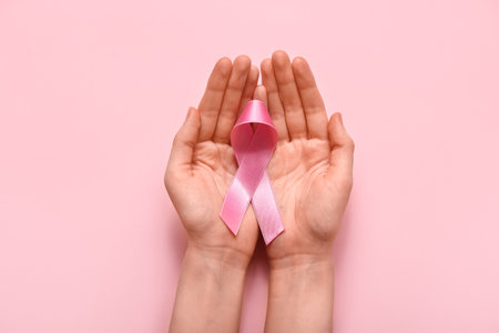 Woman with pink ribbon on color background. breast cancer awareness conceptの写真素材