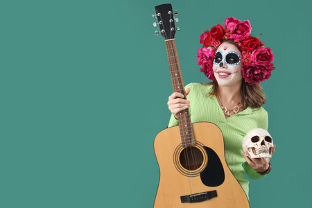 Young woman with painted skull and guitar on green background. Mexico's Day of the Dead (El Dia de...