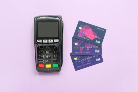Payment terminal with credit cards on lilac backgroundの写真素材