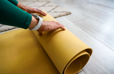 Sporty young man with yoga mat at home, closeupの写真素材