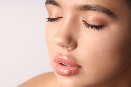 Young woman with beautiful lips on light background, closeupの写真素材